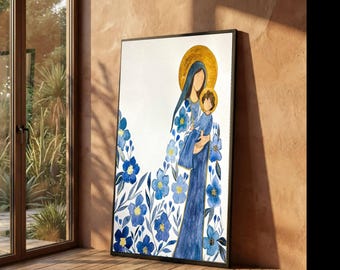 May include: A framed watercolor print depicting a mother and child with gold halos. The mother wears a blue gown adorned with blue floral patterns. The artwork is set against a white background, with a black frame. The print is leaning against a wall.