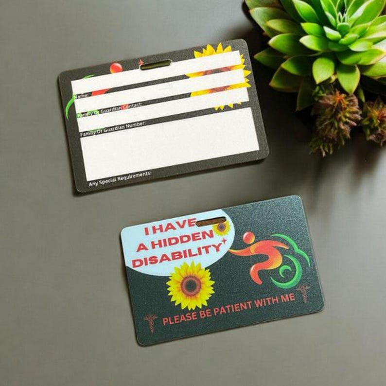 May include: Two black plastic cards with sunflower designs. The top card has blank lines for writing information, including "Family or Guardian Contact" and "Any Special Requirements". The bottom card has the text "I have a hidden disability" and "Please be patient with me".