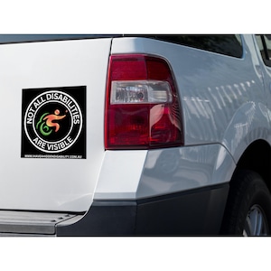 May include: A white car with a black and green sticker that says "Not All Disabilities Are Visible" with a website address below. The sticker has a symbol of a person in a wheelchair.