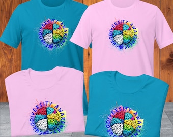 Può includere: Quattro t-shirt con una grafica di cervello colorata e il testo "Neurodiversity Awareness" in un cerchio attorno al cervello. Due t-shirt sono turchese e due sono rosa.