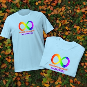 May include: Two light blue t-shirts with a rainbow infinity symbol and the text "Hidden Disability Awareness".