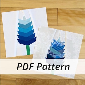 May include: Two white fabric squares with blue and white paper appliques of stylized flowers. The text "PDF Pattern" is printed on a white banner below the squares.