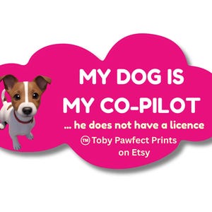 May include: A bright pink cloud-shaped sticker featuring a cartoon Jack Russell Terrier with brown and white fur. The text reads: MY DOG IS MY CO-PILOT ... he does not have a licence. Below the text is the logo for Toby Pawfect Prints on Etsy.