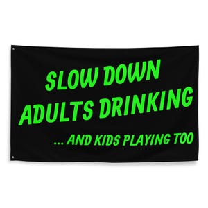 May include: Black banner with the text "SLOW DOWN DRINKING ADULTS DRINKING ... AND KIDS PLAYING TOO" in bright green. The banner is rectangular and has grommets in the corners for hanging.