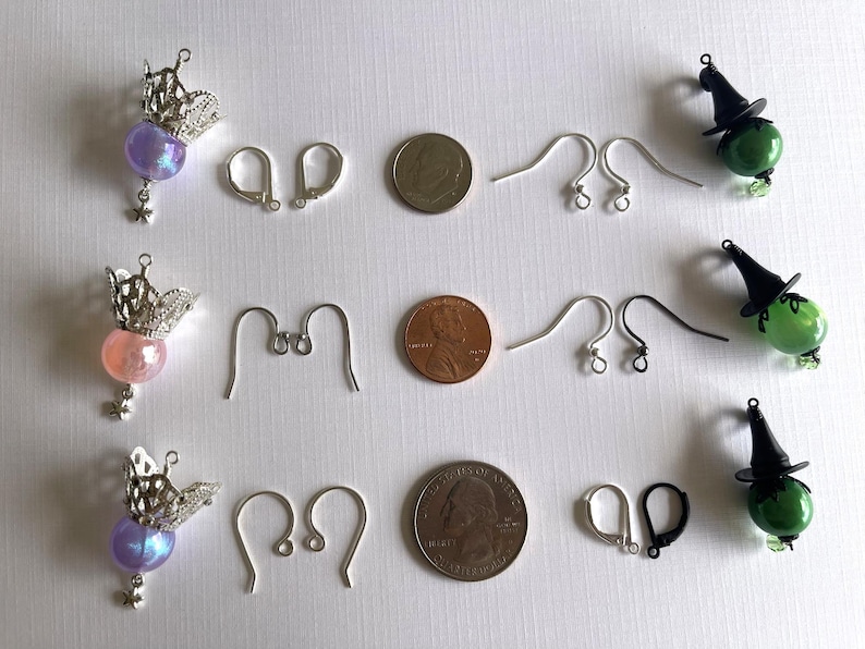 May include: An assortment of jewelry components, including three pairs of earrings with silver crowns and colorful beads, earring hooks, and coins. Also included are witch-themed earrings with green glass beads and black hats.