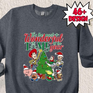 May include: A dark grey sweatshirt with a Christmas-themed design featuring the Toy Story characters Woody, Buzz Lightyear, and others. The text on the sweatshirt reads "It's the most wonderful time of the year".