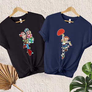 May include: Two t-shirts with Christmas-themed Toy Story characters. The black shirt features Woody holding presents and the navy blue shirt features Jessie holding a red star.