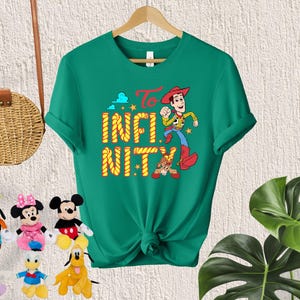 May include: Green t-shirt with a cartoon image of Woody from Toy Story. The shirt has the text "To Infinity and Beyond" printed on it.