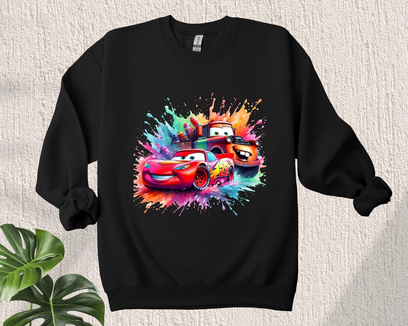 May include: Black sweatshirt with a colorful graphic of Lightning McQueen and Mater from the Cars movie. The graphic features a splash of paint effect.