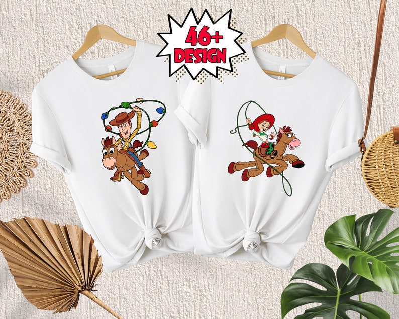 May include: Two white t-shirts with a cartoon image of Woody and Jessie from Toy Story riding a horse. Woody is wearing his cowboy hat and vest, and Jessie is wearing her red dress and hat. The shirts are tied together in a knot.