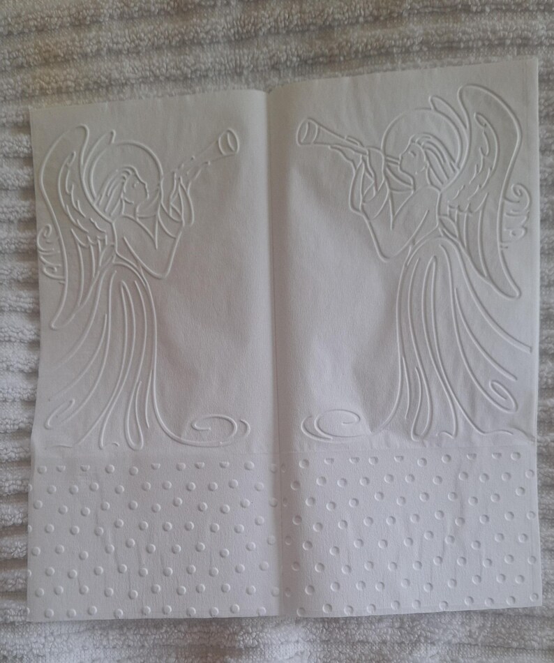 Pu&ograve; includere: Due fogli di carta bianca con disegni di angeli in rilievo. Ogni angelo suona la tromba, con ali e vesti dettagliate. La parte inferiore di ogni foglio presenta un bordo a pois, creando un effetto strutturato.