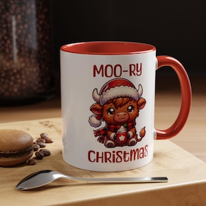 May include: White ceramic mug with a red rim and handle. The mug features a cartoon illustration of a brown Highland cow wearing a Santa hat and scarf, holding a cup of hot chocolate. The text "MOO-RY CHRISTMAS" is printed on the mug.