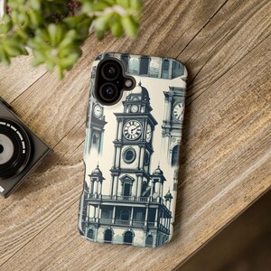 Peut inclure: Une coque de téléphone avec un motif répété d'une tour d'horloge en bleu et crème. Le motif de la tour de l'horloge comprend un grand cadran et des détails architecturaux. L'étui est présenté sur une surface en bois.