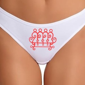 May include: White underwear with a red decorative design on the front. The design is a stylized, symmetrical pattern with swirls and circles. The underwear is made of a soft, comfortable material.