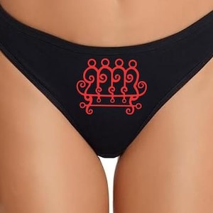 May include: Black underwear with a red graphic print. The graphic is a stylized, symmetrical design featuring four figures above a horizontal line with decorative swirls.