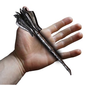 Può includere: Una mazza dettagliata in stile antico con una testa a punte e un manico strutturato. La mazza è realizzata in un materiale metallico scuro, forse ferro o acciaio. Il design suggerisce un tema medievale o fantasy.