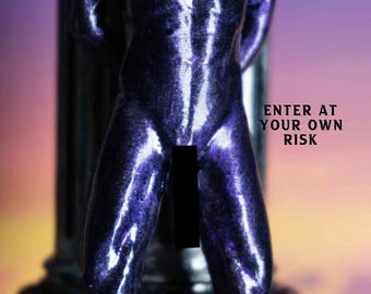 May include: A metallic purple sculpture of a human torso with arms positioned behind the back, standing on a dark base. The text ENTER AT YOUR OWN RISK is printed in black on the right side. A black rectangular bar obscures the center area.