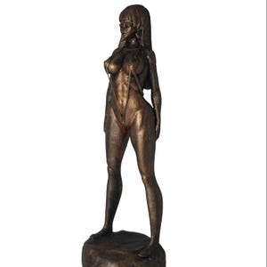 Könnte beinhalten: Bronzefarbene Statue einer Frau in einem Badeanzug, die auf einem felsartigen Sockel steht. Die Figur hat langes Haar und ist mit einem Bein leicht nach vorne posiert. Die Statue hat eine detaillierte, strukturierte Oberfläche.