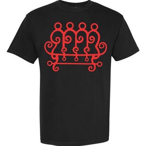 May include: Black t-shirt with a red graphic design. The design features a series of connected figures with swirling details, arranged above a horizontal line with decorative elements. The shirt has short sleeves and a crew neck.