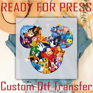 May include: A light gray t-shirt featuring a colorful graphic of Disney characters arranged in the shape of Mickey Mouse's head. The words "READY FOR PRESS" and "CUSTOM DTF TRANSFER" are printed on the image.