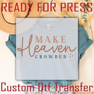 May include: Light blue t-shirt with the words "MAKE Heaven CROWDED" in brown and peach lettering. The words "READY FOR PRESS" and "Custom Dtf Transfer" are also visible in red and white.