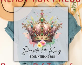 Könnte beinhalten: Hellblaues T-Shirt mit einem Aquarelldesign einer rosa und goldenen Krone, die mit Juwelen verziert ist. Der Text "Daughter of the King" und "2 Corinthians 6:18" befinden sich unter der Krone. Die Worte "READY FOR PRESS" und "CUSTOM Dtf TRANSFER" stehen oben und unten.
