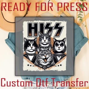 May include: A graphic DTF transfer featuring a design of four cats in rock band makeup, with the word "HISS" in a bold, stylized font. The design includes stars and text that reads "READY FOR PRESS" and "CUSTOM DTF TRANSFER".