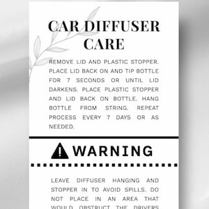 May include: A white card with black text detailing car diffuser care instructions. The text includes usage steps and a warning about spills and safety. A decorative leaf design is at the top.