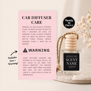 Può includere: Un profumatore per auto con tappo in legno e cordino, accanto a un biglietto rosa con istruzioni per la cura e un avvertimento. L'etichetta sulla bottiglia recita "SCENT NAME" e "CAR DIFFUSER". È visibile anche un adesivo "Ready to Print".