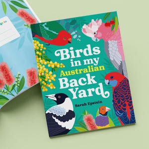 May include: A book cover with the title "Birds in my Australian Back Yard" by Sarah Epstein. The cover features colourful illustrations of Australian birds, including a cockatoo, a magpie, and a lorikeet, against a green background with yellow wattle flowers.