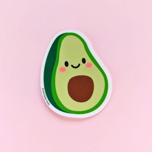 May include: A die-cut sticker of a smiling avocado with a brown pit, light green flesh, and dark green skin. The avocado has pink cheeks and a white border. The sticker is on a pink background. The text "© Sarah Epstein Studio" is printed on the sticker.