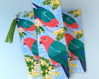 May include: Three colourful bookmarks featuring a parrot with red, green and blue feathers. The bookmarks are printed on a white background with yellow flowers.