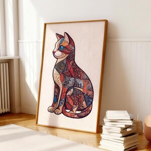Peut inclure: Impression artistique encadr&eacute;e repr&eacute;sentant un chat stylis&eacute;. Le chat est assis, avec un motif patchwork rouge, bleu et marron. L'&oelig;uvre est sur fond cr&egrave;me, encadr&eacute;e dans un cadre en bois marron clair. L'impression est pos&eacute;e sur un sol en bois.