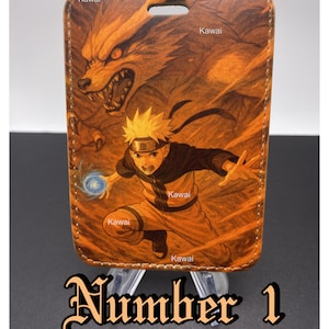 May include: A rectangular phone case featuring a vibrant illustration of an anime character with spiky yellow hair, a blue energy ball, and a large orange fox. The case has a brown border and the text "Number 1" at the bottom.