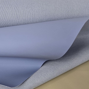 May include: A close-up of two pieces of fabric. The top piece is a light blue, textured fabric. The bottom piece is a solid, light blue fabric.