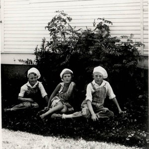 vintage foto Niños jóvenes todos usando Flapper era Beret Caps Overalls Siéntate en hierba