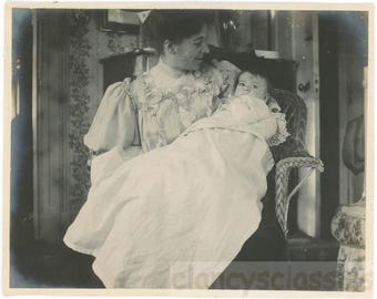 Foto d'epoca 1899: Una neomamma tiene in braccio un neonato avvolto in una coperta su una sedia di vimini 78 B