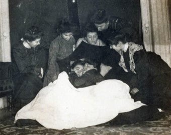 Vintage foto uit de jaren 1900. Liefdevolle vrouwen omhelzen elkaar wang aan wang, terwijl anderen toekijken. Lesbische int 70 H