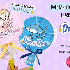 May include: Bubble pop wands with circular designs. One features a coffee cup ballerina, the other a shark wearing sneakers. Text includes "Happy Children's Day" and "Bubble Pop." The wands are decorated with ribbons and tags. The background is a light purple.