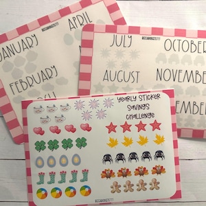 Op de afbeelding: Drie witte kaarten met roze ruitjesranden tonen de maanden van het jaar, met een vel stickers met seizoensgebonden iconen. De stickers bevatten harten, klavers, sterren en meer, voor een spaaruitdaging.