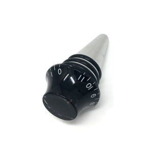 May include: A silver and black bottle stopper with a numbered dial. The dial has numbers from 0 to 11.