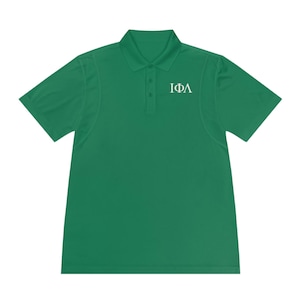 Puede incluir: Una camisa polo verde con un diseño bordado de letras griegas blancas que dice "IΦA".