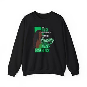 Może przedstawiać: Czarna bluza z zielonym i czarnym nadrukiem przedstawiającym twarz kobiety i tekst "I am Black every month but this month I'm Blackity Black Black Black".