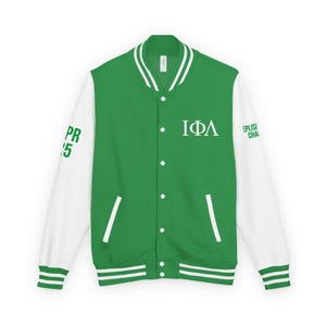 Könnte beinhalten: Grün-weiße Collegejacke mit den griechischen Buchstaben IΦΛ auf der Brust. Die Ärmel sind weiß und der Körper ist grün. Auf dem linken Ärmel steht "PR '15" und auf dem rechten Ärmel "EPLISI CHA".