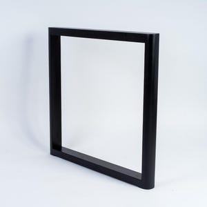 May include: A black, rectangular frame with a square profile. The frame is made of a solid material and has a matte finish. The frame is designed to stand upright and is suitable for various uses.
