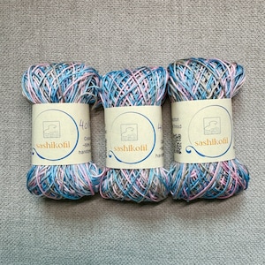 May include: Three spools of blue, pink, and gray cotton embroidery floss with a label that reads "sashikofil" and "40/2 Cotton Thread".