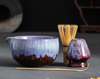 Peut inclure: Un service à thé matcha en céramique avec un glaçage bleu et marron. L'ensemble comprend un bol, un fouet, un porte-fouet et une cuillère en bambou. Le bol à thé a un bec verseur. Le fouet est en bambou.