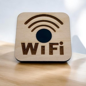 Könnte beinhalten: Ein Holzschild mit dem Wort "Wi-Fi" und einem stilisierten Wi-Fi-Symbol in Schwarz.