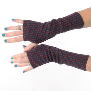 May include: A pair of fingerless gloves with a navy blue background and a red diamond pattern.