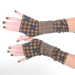 May include: A pair of brown and blue fingerless gloves with a houndstooth pattern. The gloves have a plaid cuff.